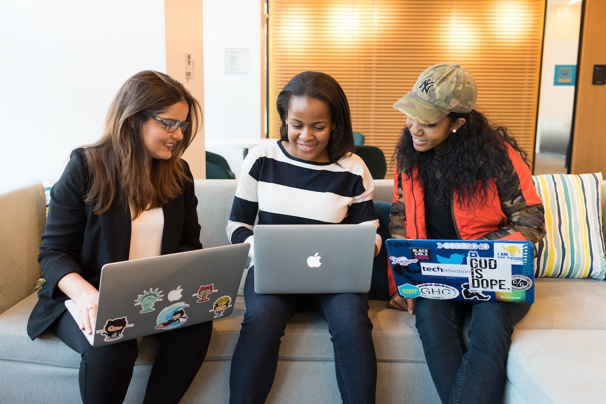 image of 3 women at work wide by side as they work together on laptops