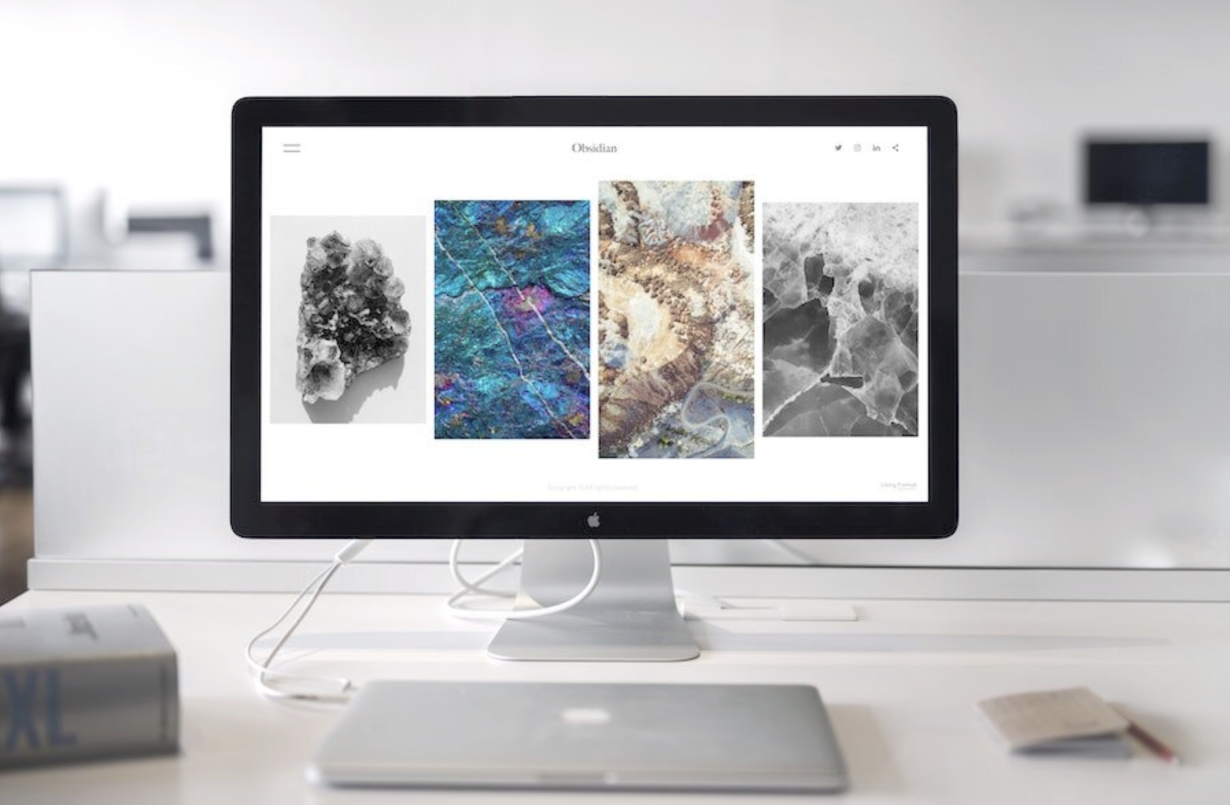 decorative image of an apple laptop that's closed in front of an external monitor
